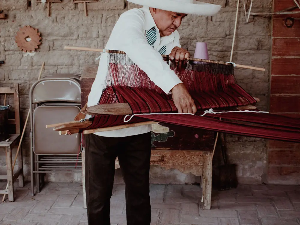 Artesano tejiendo en un telar de cintura tradicional